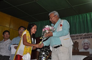 The Governor of Arunachal Pradesh Shri P.B. Acharya felicitating wife of Martyr Hav. Hangpan Dada, Ashok Chakra (posthumous) Ms Chasen Lowang Dada in a public meeting  at Khonsa, Tirap District on 29th August 2017